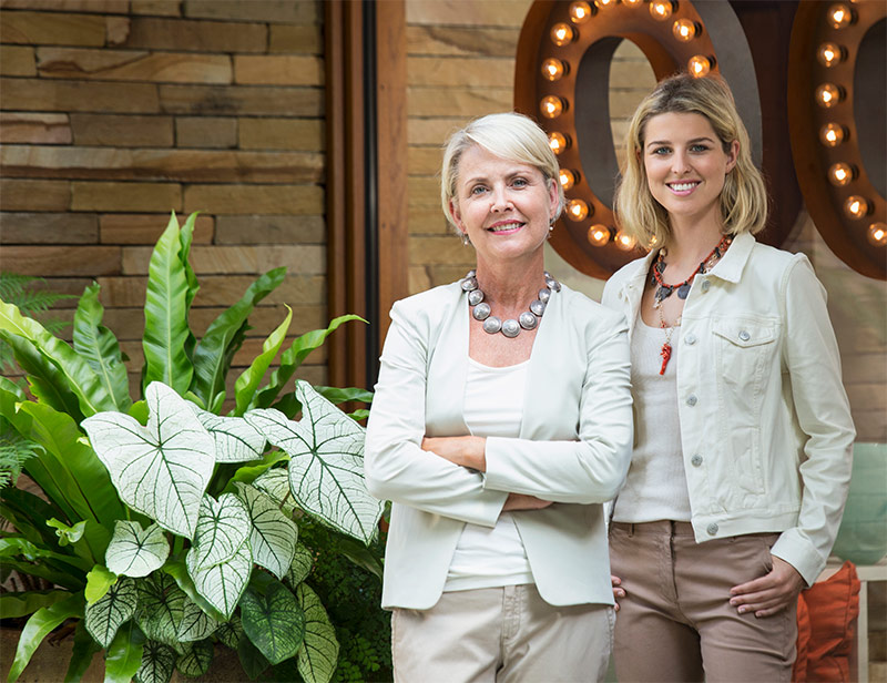 A picture of two women standing beside each other, smiling at the camera.